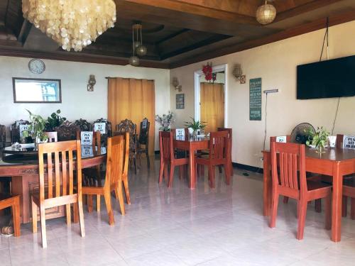 a dining room with wooden tables and chairs at The Lighthouse Resort in Oslob