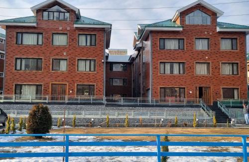 a group of buildings with snow in front of them at White Water Resorts in Pahalgām