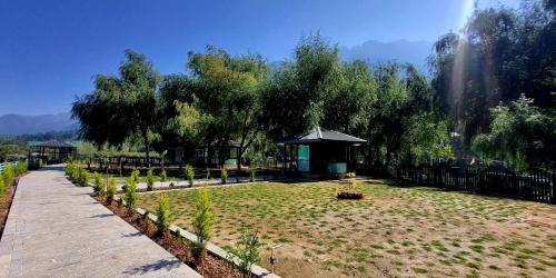 a garden with a gazebo in the middle of a field at White Water Resorts in Pahalgām