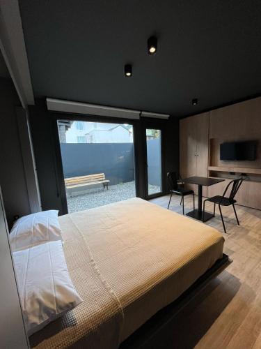 a bedroom with a large bed and a table with chairs at Edificio Pantera - monoambiente de diseño in San Martín de los Andes