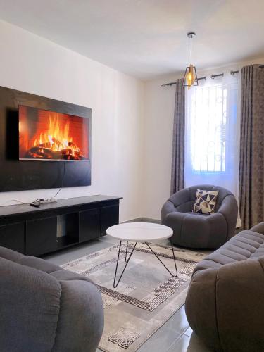 a living room with two couches and a fireplace at NishHomes in Mombasa