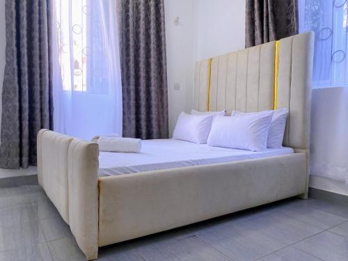 a bed with a large headboard in a room at NishHomes in Mombasa