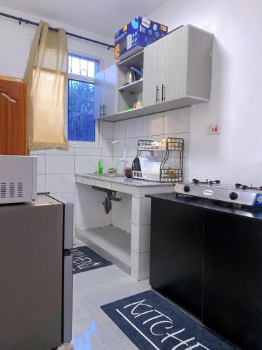 a kitchen with a sink and a stove in it at NishHomes in Mombasa