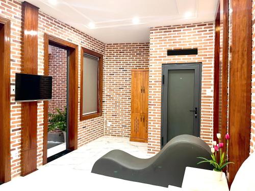 a living room with a couch and a brick wall at The Land Hotel & Apartment in Vung Tau