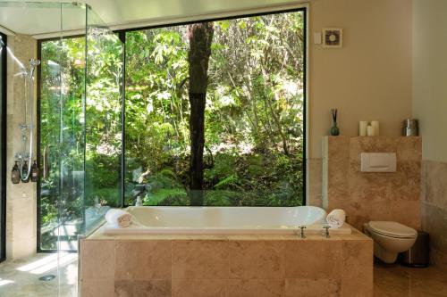 a bath tub in a bathroom with a large window at The Point Villas in Taupo