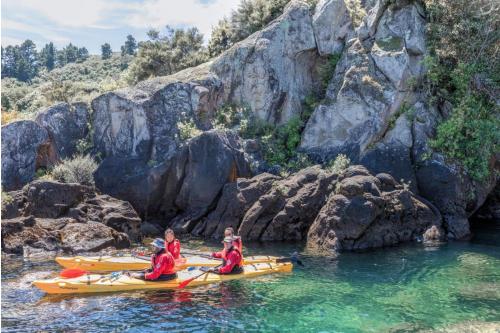 a group of people in kayaks on a river at The Point Villas in Taupo