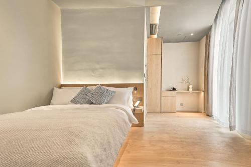 a bedroom with a bed and a large window at The Yard Boutique Hotel Shanghai 一隅酒店上海虹桥漕河泾店 in Shanghai