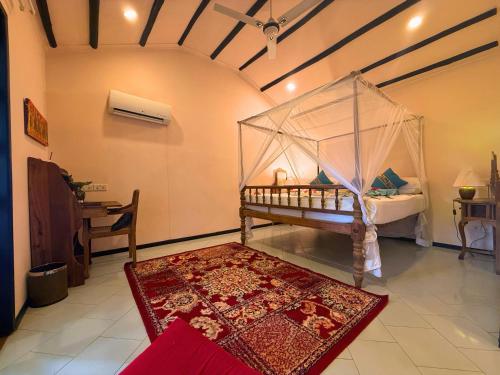 a bedroom with a bed with a mosquito net at Mbweni Ruins & Gardens Previously Jungle Paradise in Zanzibar City