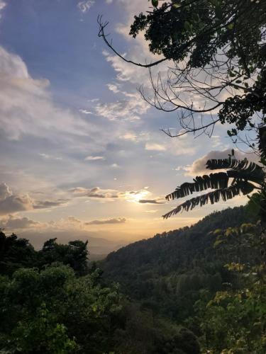 a view of a valley with the sunset in the background at D'Langun Bali in Munduk