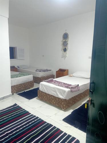 three beds in a room with mats on the floor at فندق جرين فالي دهب - Green Valley Hotel in Dahab