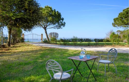 a table and chairs in the grass with a fence at Amazing Home In Montemarciano With Wifi in Alta Marina