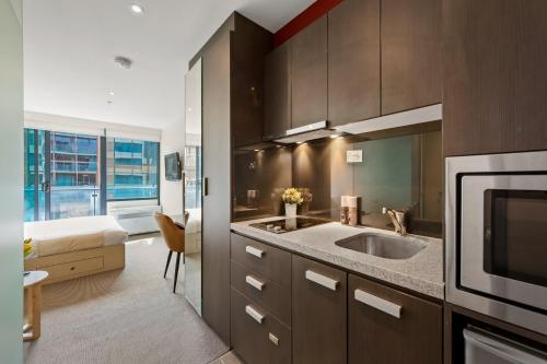 a kitchen with a sink and a microwave at City Stays in Melbourne