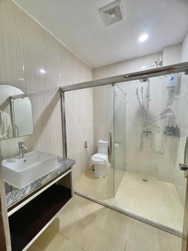 a bathroom with a shower and a sink and a toilet at Ocean Star Coron in Coron