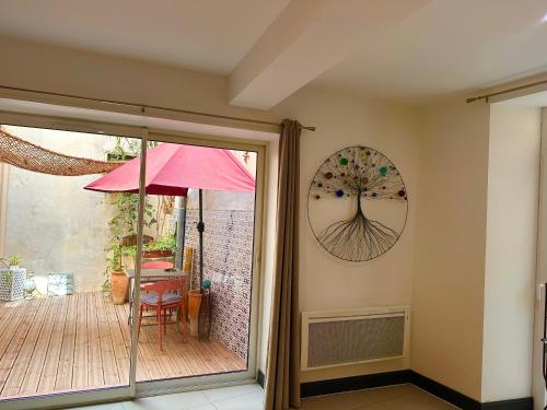 une terrasse avec un parasol et une table avec une chaise dans l'établissement ART'APPART, à Narbonne