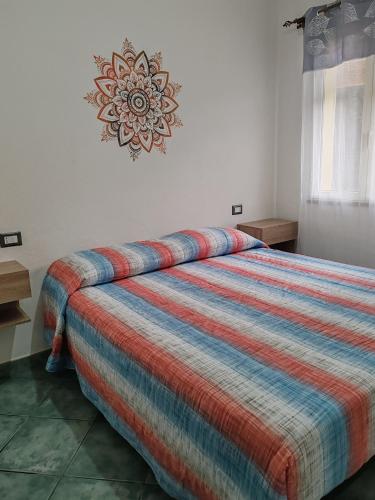 a bedroom with a bed with a colorful comforter at La Mimosa Bianca in Tertenìa