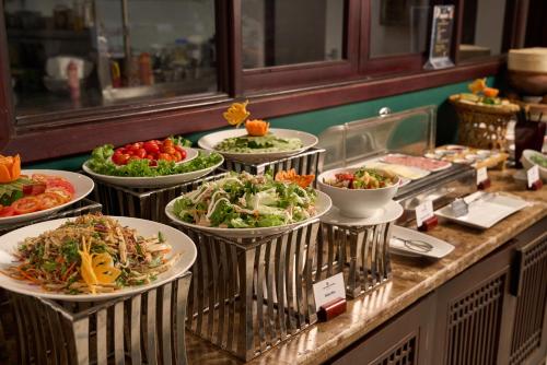a buffet with many plates of food on a counter at Hoi An Odyssey Hotel & Spa in Hoi An