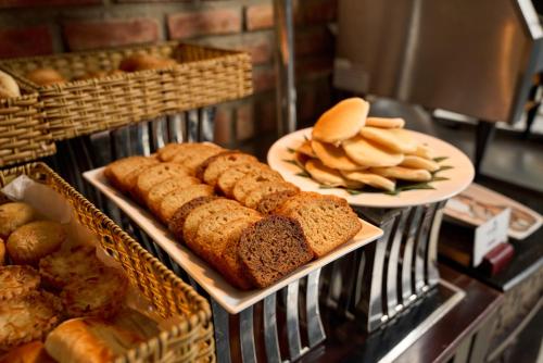 a counter with two plates of bread and some breadsticks at Hoi An Odyssey Hotel & Spa in Hoi An