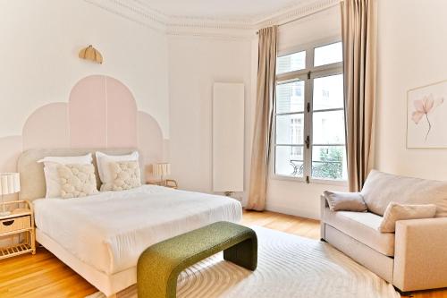 - une chambre blanche avec un lit et un canapé dans l'établissement Appartement moderne et climatisé - Arc de Triomphe, à Paris
