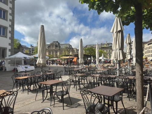 a group of tables and chairs with white umbrellas at Fribourg Studio Home in Fribourg