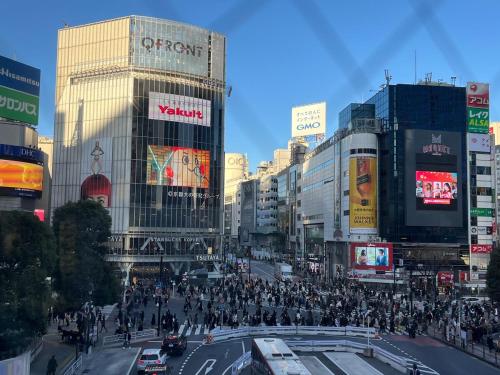 a crowd of people crossing a street in a city at Zen Japanese room up to four Shinjuku 20 minutes Walmart DonDonDonki 7 minutes from station Free parking Quiet area at Tanashi Station in Nishitokyo