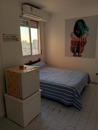 a bedroom with a bed and a painting on the wall at El rincón de boedo in Buenos Aires