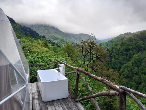 a white bath tub sitting on top of a wooden deck at Glamping Machakhela 2 in Ch'ik'unet'i