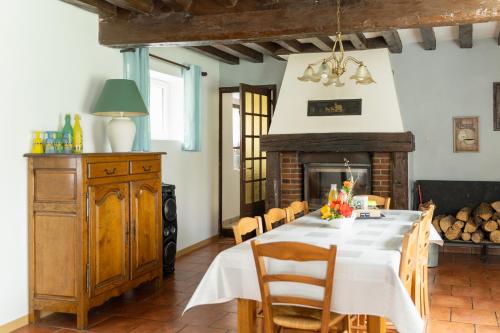 une salle à manger avec une table et une cheminée dans l'établissement Gite de l'étang, à La Puisaye