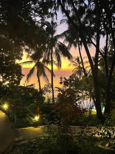 a sunset view from a beach with palm trees at Mbweni Ruins & Gardens Previously Jungle Paradise in Zanzibar City