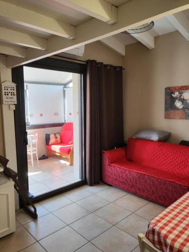 une pièce avec deux canapés rouges et un salon dans l'établissement Le Barcares 100 m plage et commerces, à La Celle-sous-Gouzon