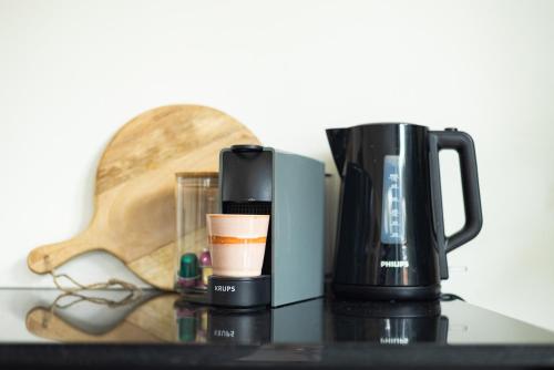 a coffee maker sitting on top of a table at VlieMare Appartementen De Kluut in Oost-Vlieland