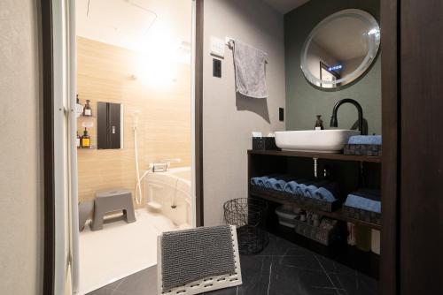 a bathroom with a shower and a sink and a toilet at おやど紀伊国屋籠町 in Nagasaki