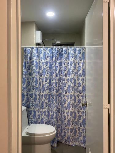 een badkamer met een toilet en een blauw douchegordijn bij Casa Moderna Iloilo in Iloilo City