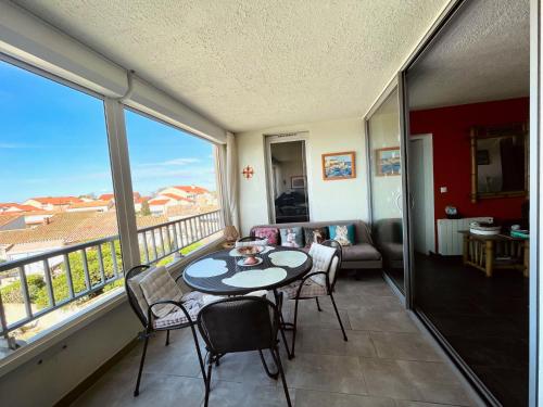 d'un balcon avec une table, des chaises et un canapé. dans l'établissement Les Dunes34, à Le Castellas