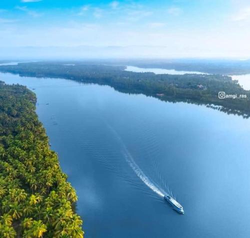 a boat in the middle of a body of water at Kavvayi Kayaloram The Arabian Beach House in Kokkānisseri