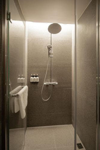 a bathroom with a shower and a sink at The Yard Boutique Hotel Shanghai 一隅酒店上海虹桥漕河泾店 in Shanghai
