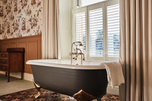 a bath tub in a bathroom with a window at Bank House, Bushmills in Bushmills