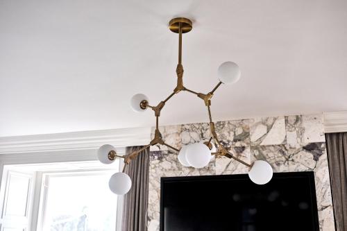 a chandelier in a living room with a tv at Bank House, Bushmills in Bushmills