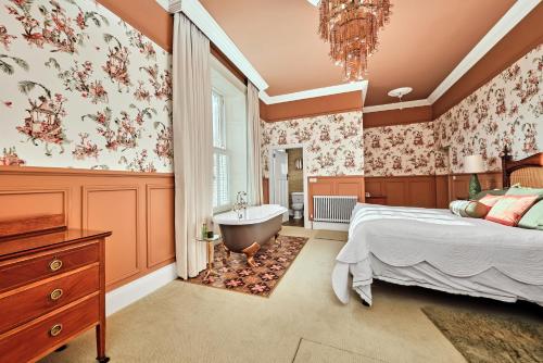 a bedroom with a bed and a bath tub and a sink at Bank House, Bushmills in Bushmills