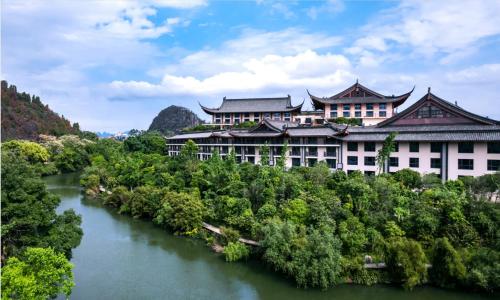 a building with a river in front of it at Grand Bravo Guilin in Guilin