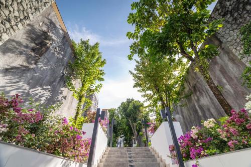 a stairway with flowers on the side of a building at Phuket Moonlit Bay Seaview Resort & Spa in Phuket