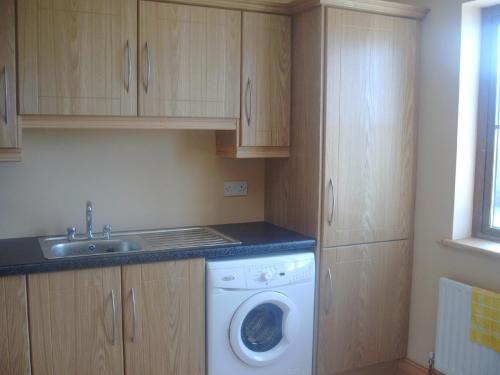 a kitchen with a washing machine and a sink at Ocean View Doogort in Doogort