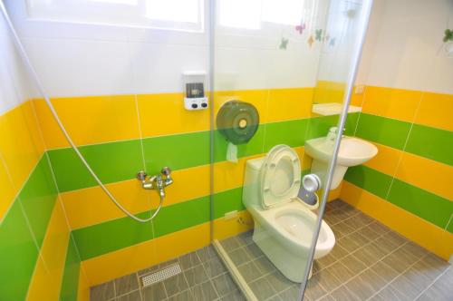 a colorful bathroom with a toilet and a shower at Dream Homestay in Huxi