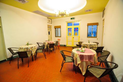 a dining room with tables and chairs and a chandelier at Dream Homestay in Huxi