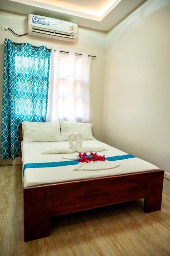 a bed with flowers on top of it in a room at La Jose Beach Resort in Pagudpud