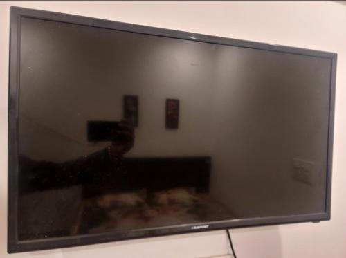 a television screen with a person taking a picture at Old School Appartment in Kapūrthala