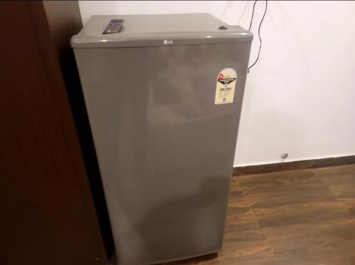 a small grey refrigerator with a sticker on it at Old School Appartment in Kapūrthala