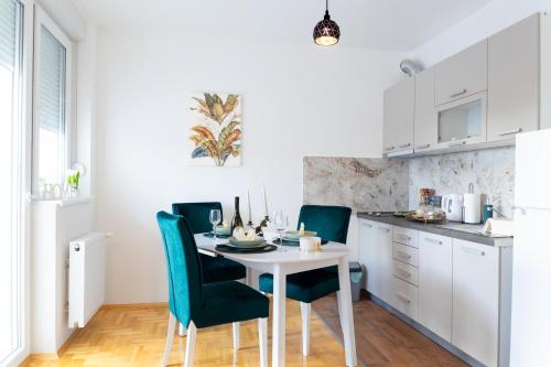 a kitchen with a white table and chairs at Lana Lux 18 in Subotica