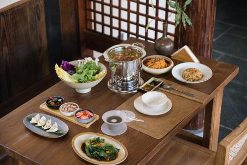 a wooden table with dishes of food on it at Hegu Retreat Qingcheng in Jiezi Ancient Town