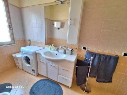 a bathroom with a sink and a washing machine at Diana Apartment Briatico in Briatico