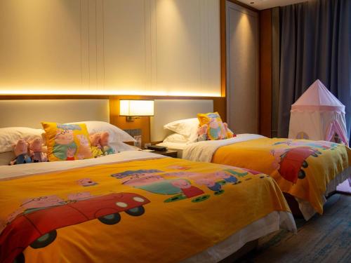a bedroom with two beds with dolls on them at Shangrao International Hotel in Shangrao